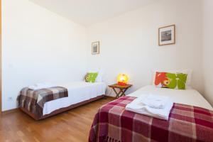 1 Schlafzimmer mit 2 Betten und einem Tisch in der Unterkunft FLH Expo Flat with View in Lissabon