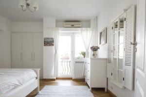 ein weißes Schlafzimmer mit einem Bett und einem Fenster in der Unterkunft Diana's Flat-the best-Bucharest - Old City in Bukarest