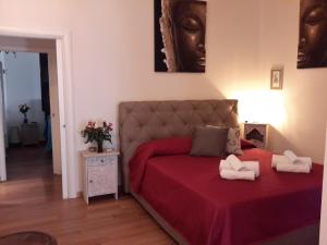 Un dormitorio con una cama con una colcha roja. en Le Stanze di Penelope, en Salerno