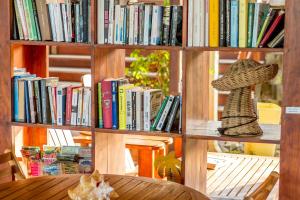 un estante lleno de libros con un sombrero en Hôtel Résidence Océane, en Tartane