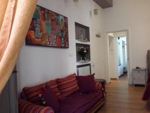 Una sala de estar con un sofá y un cuadro en la pared. en Le Stanze di Penelope, en Salerno