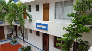 a building with palm trees in front of it at Hotel Carruiz in Puerto Escondido