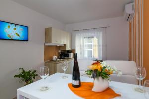 a table with a bottle of wine and flowers on it at Apartments Trend 2 in Rijeka