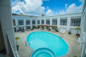 - une grande piscine dans la cour d'un bâtiment dans l'établissement Royal Orchid Hotel Guam, à Tumon