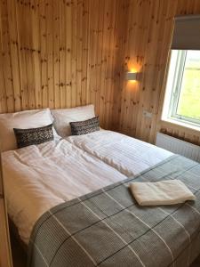 Cama grande en habitación con paredes de madera en Hekla Adventures en Hvolsvöllur