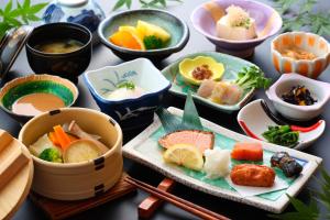 a table topped with bowls and plates of food at Yamabiko Ryokan in Minamioguni