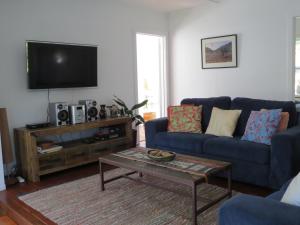 a living room with a blue couch and a coffee table at Coromandel Eco Sanctuary in Coromandel Town
