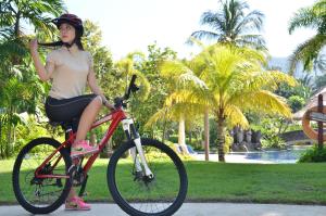 uma mulher está sentada numa bicicleta num parque em Merumatta Senggigi Lombok em Senggigi