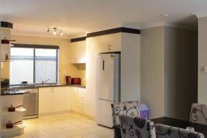 a kitchen with white cabinets and white appliances at Atricom in Stanthorpe