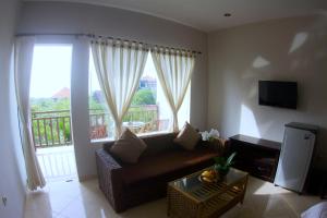 ein Wohnzimmer mit einem Sofa und einem großen Fenster in der Unterkunft Ropik & Alik Home Stay in Uluwatu