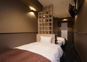 Ένα ή περισσότερα κρεβάτια σε δωμάτιο στο Hotel SUI Ginza Kyobashi by ABEST