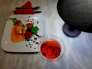 un plato de comida y una copa de vino en una mesa en Arte Brasileira, en Salvador