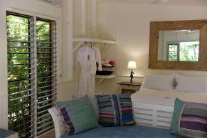 a bedroom with a bed and a mirror at Sejala Beach Huts in Mission Beach