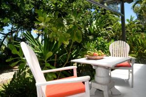 Mission Beach的住宿－思雅拉海灘小屋酒店，两张椅子和一张桌子,上面放着一碗水果