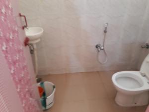 a bathroom with a toilet and a sink at Arun Cottages in Mahabalipuram
