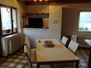 - une cuisine et une salle à manger avec une table et des chaises dans l'établissement Casa Erica frazione Carano, à Carano
