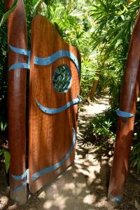 a wooden gate with a hole in the middle at Sejala Beach Huts in Mission Beach