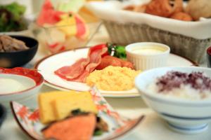 a table with plates of food and bowls of food at Hotel Monterey Kyoto in Kyoto