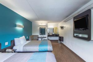 a hotel room with two beds and a flat screen tv at Motel 6-Overland Park, KS in Overland Park