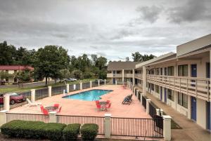 un balcón con vistas a la piscina de un hotel en Super 7 Inn, en Tupelo