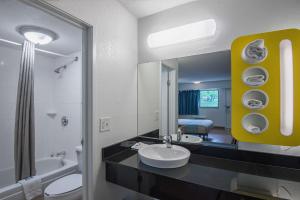 a bathroom with a sink and a toilet and a mirror at Motel 6-Overland Park, KS in Overland Park +19 photos