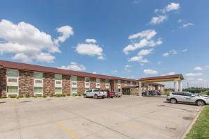 un gran edificio con coches estacionados en un estacionamiento en Motel 6 Omaha - Central en La Vista