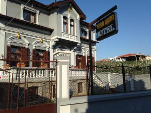 un edificio blanco con un cartel delante en Hotel Vila Mano, en Korçë