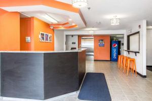 a bar in a lobby with orange walls and orange stools at Motel 6-Streetsboro, OH in Streetsboro