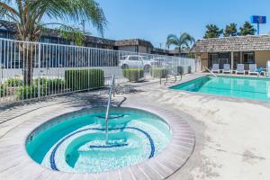 a swimming pool with a fountain in a yard at Motel 6-Kingsburg, CA in Kingsburg