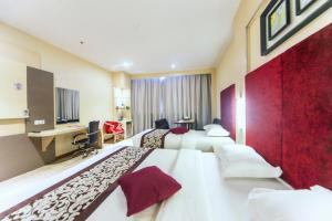ナゴヤにあるバタム シティ ホテルのベッド2台とデスクが備わるホテルルームです。