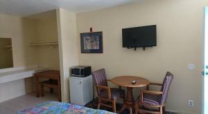 a room with a table and a television on the wall at Bristol Motel in Long Beach