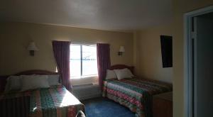 a hotel room with two beds and a window at Bristol Motel in Long Beach