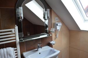 a bathroom with a sink and a mirror at Pensiunea Koruna in Poenari