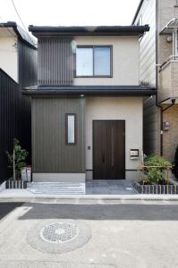 a house with a brown door and a driveway at Ya -MIYABI in Kyoto