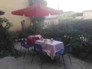 a table with a red umbrella and blue chairs at B&B Lago Mulargia in Siùrgus Donigala
