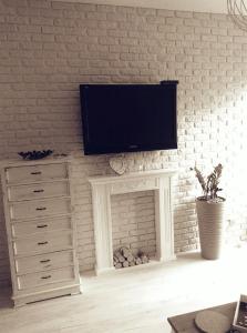 a living room with a tv above a fireplace at Przystań parking ogródek blisko jeziora i mariny dla jachtów in Ostróda