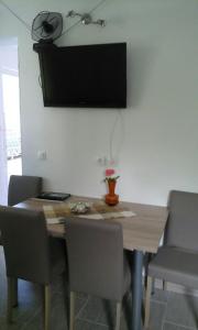 einen Esstisch mit Stühlen und einen TV an der Wand in der Unterkunft Apartment Nane in Trogir