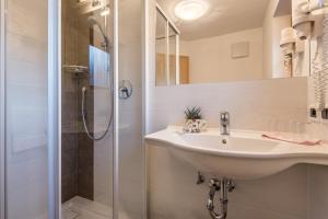 a bathroom with a sink and a shower at Ciasa Roch in Corvara in Badia