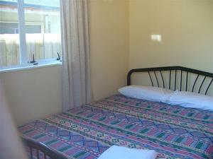 Bett in einem Zimmer mit Fenster in der Unterkunft Holiday Chalet in National Park