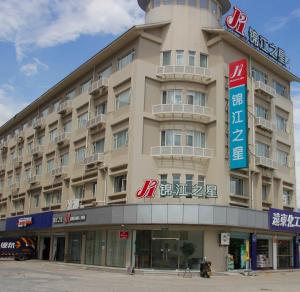 um grande edifício com uma placa em frente em Jinjiang Inn Putian East Wenxian Road em Putian