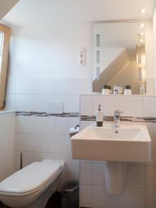 Baño blanco con lavabo y aseo en Gastezimmer Richter en Dresden