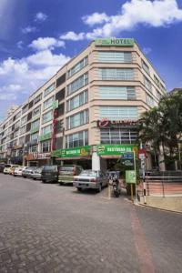 een groot gebouw met auto's geparkeerd voor het bij One Avenue Hotel in Petaling Jaya