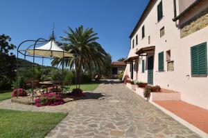 a patio with a table and an umbrella next to a building at Residence della Luna in Porto Azzurro