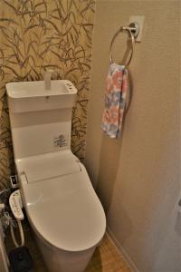 La salle de bains est pourvue de toilettes et d'une serviette accrochée au mur. dans l'établissement Peace house Abeno, à Osaka