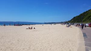 un grupo de personas en una playa cerca del océano en Boscombe Reef Hotel en Bournemouth