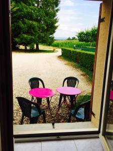 une table et des chaises roses à l'extérieur d'une fenêtre dans l'établissement la ferme de Martine, à Lent