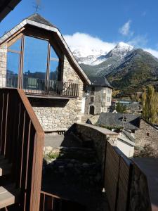 Elle offre une vue sur un bâtiment doté d'un balcon et des montagnes. dans l'établissement La Borda del Zarrastiecho, à Sallent de Gállego