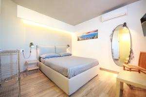 ナポリにあるTalismano Luxury Suite & Loft & Alcovaのベッドルーム1室(ベッド1台、鏡、テーブル付)