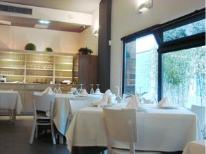 a dining room with white tables and white chairs at Hotel Zelaa in Zaldivia