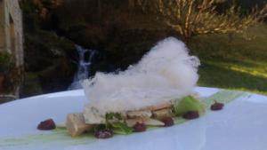 un pezzo di cibo su un piatto con del fumo sopra di Logis Hotel Restaurante La Casa de Juansabeli a Arenas de Cabrales